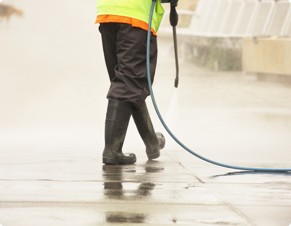 Person cleaning sidewalk with hose