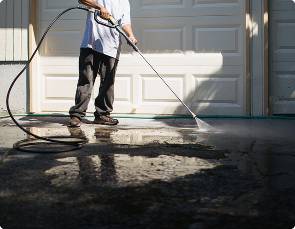 Person pressure washing driveway